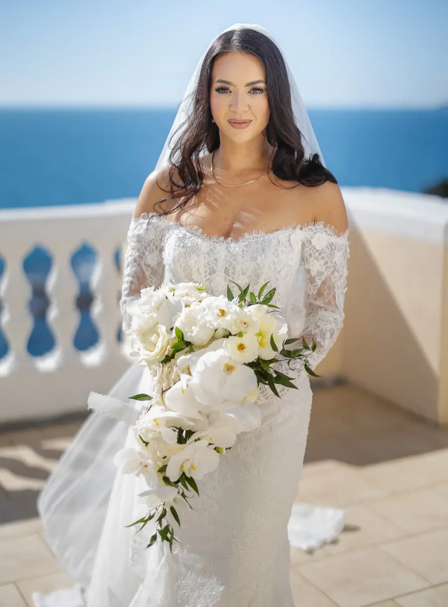 Nicolette con velo e bouquet sulla terrazza di Villa Parisi con il mare alle spalle