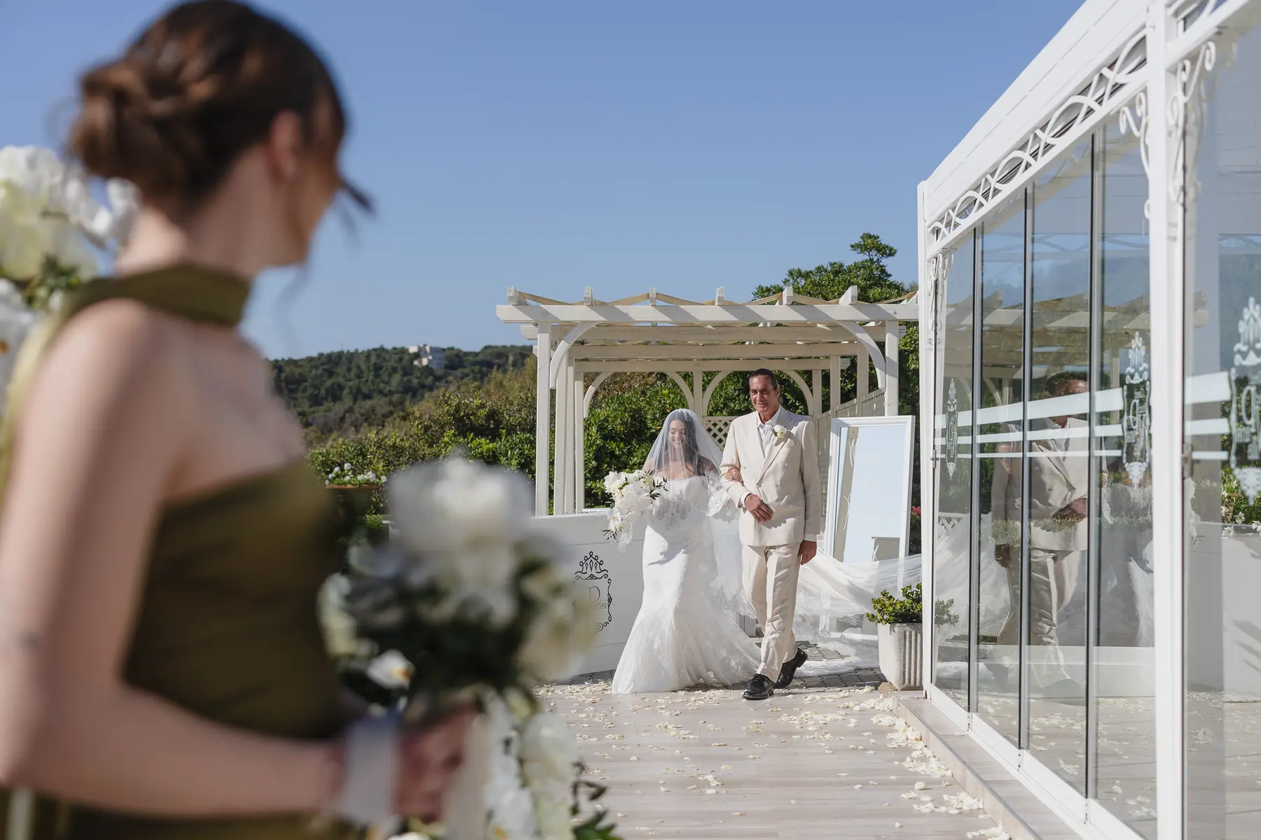 La sposa accompagnata dal padre verso la cerimonia in terrazza a Castiglioncello