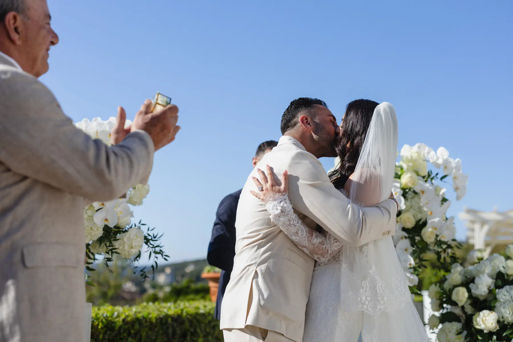 Gli sposi sorridenti escono dalla cerimonia tra i petali lanciati dagli invitati