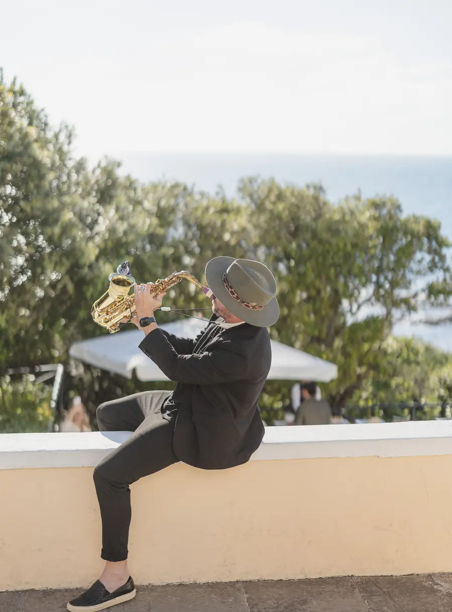 Sassofonista con cappello suona dal vivo al matrimonio sul mare a Castiglioncello