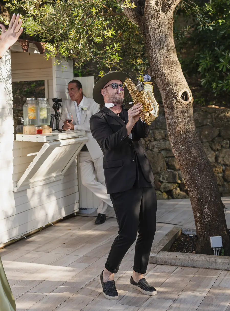 Il sassofonista anima l'aperitivo tra gli ospiti sotto gli alberi di Villa Parisi