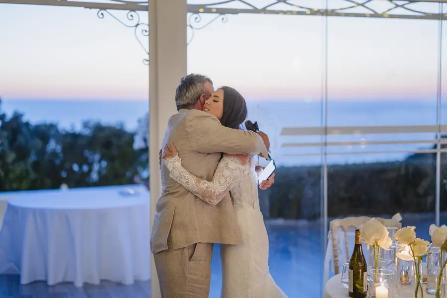 Abbraccio commosso tra la sposa e un familiare durante la cena di nozze