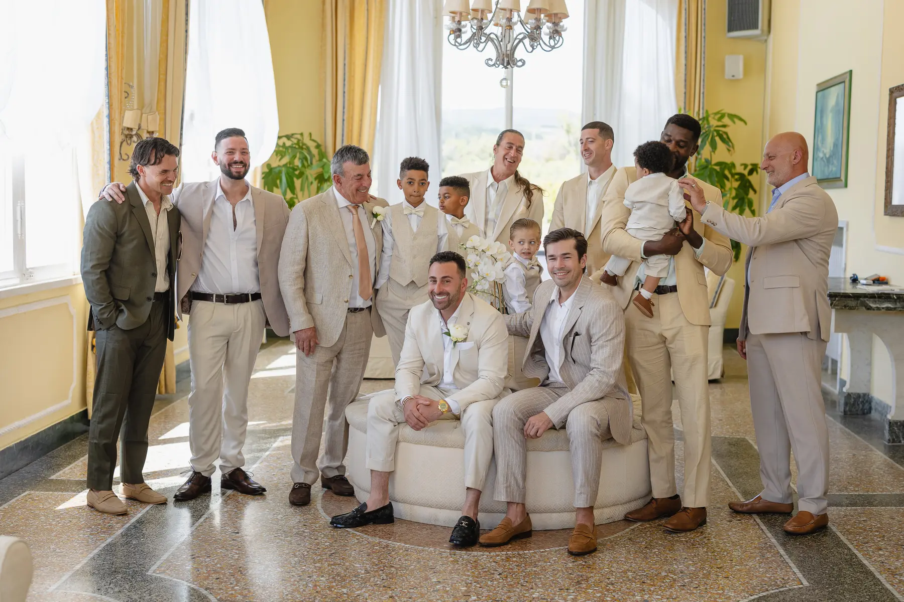 Lo sposo con amici, parenti e bambini in abiti beige prima del matrimonio