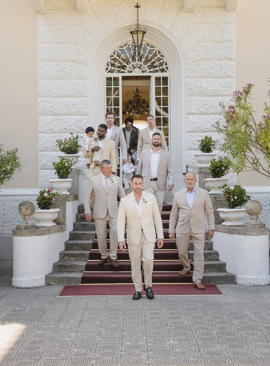 Lo sposo scende la scalinata di Villa Parisi con amici e parenti verso la cerimonia